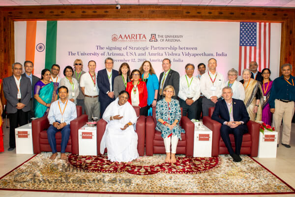 A group of people standing in front of a crowd posing for the camera

Description automatically generated